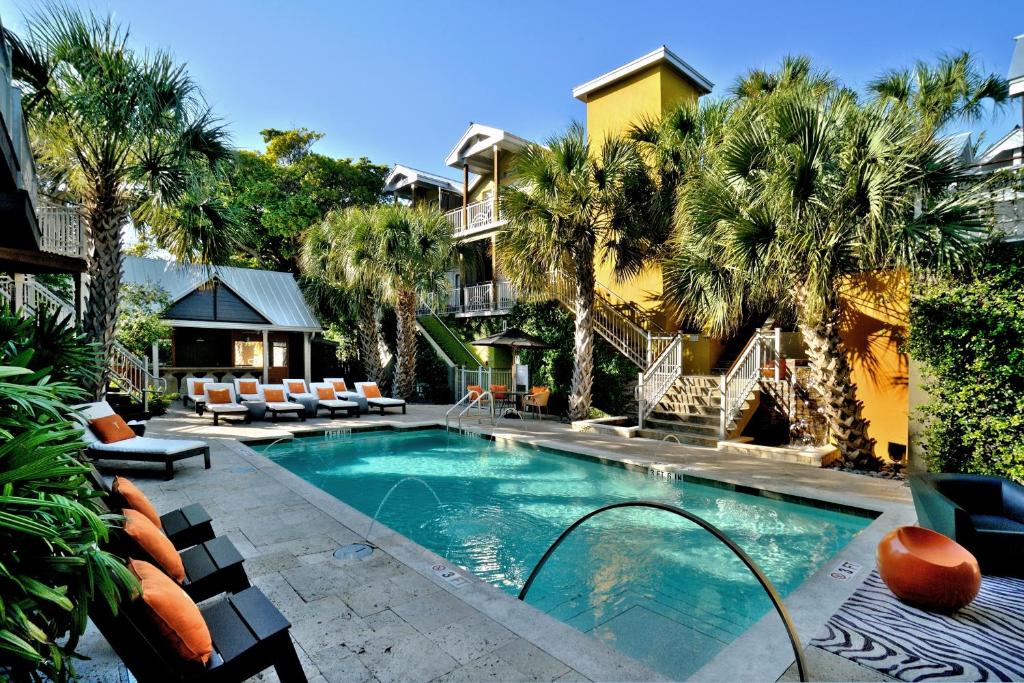 a swimming pool with palm trees and a building at Truman Hotel in Key West