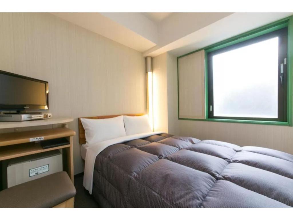 熊谷市にあるR&B Hotel Kumagaya Ekimae - Vacation STAY 40478vのベッドとテレビがあるホテルの部屋