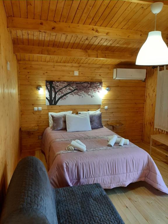 a bedroom with a bed in a wooden cabin at Quinta do Pinheiro in Grândola