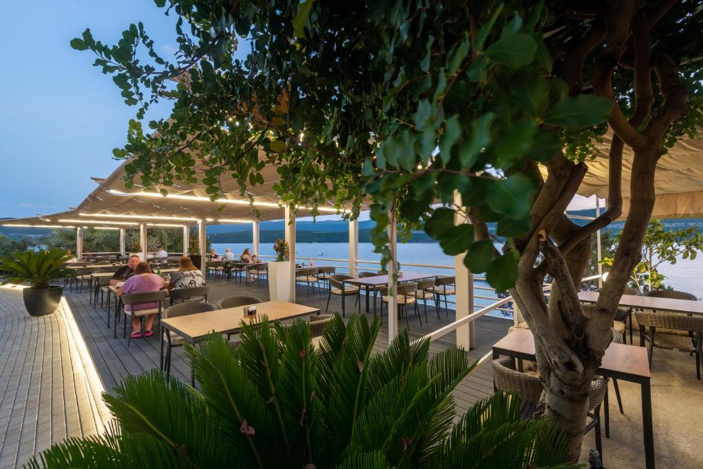 un restaurante con mesas y sillas en la playa en Hotel Porat, en Neum