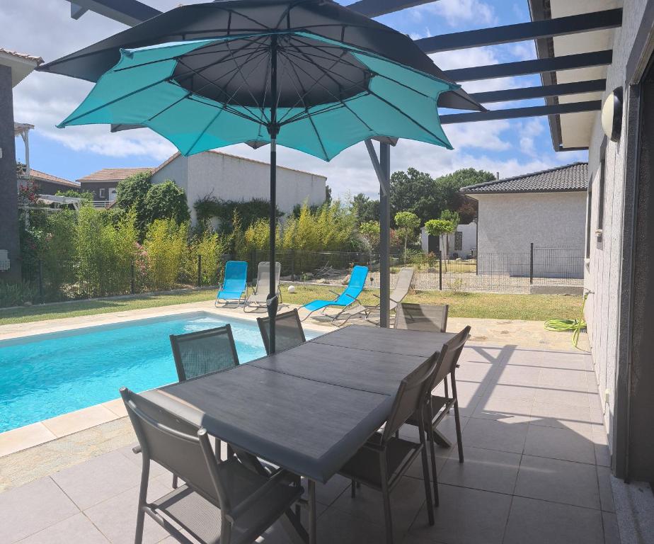 - une table et des chaises avec des parasols sur la terrasse dans l'établissement Villa Cosy avec piscine privative, à Ghisonaccia