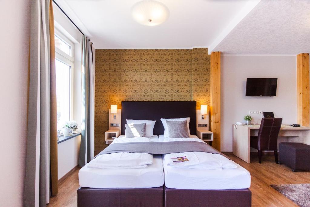 a bedroom with a large bed and a desk at Mayer's Weinhotel in Zell an der Mosel