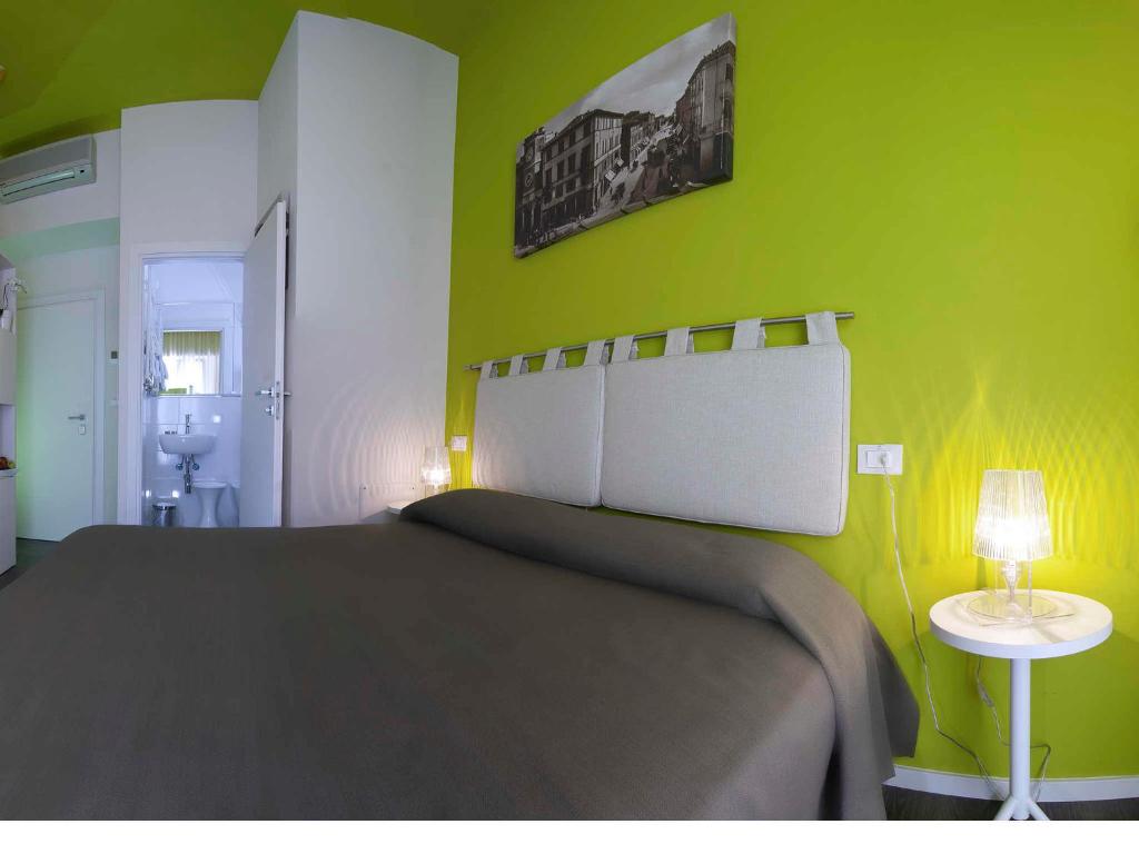 um quarto com uma cama grande e uma parede verde em Hotel Casablanca em Rimini