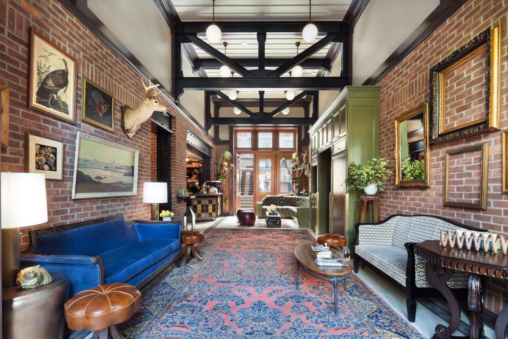a living room with a blue couch and a brick wall at The High Line Hotel in New York