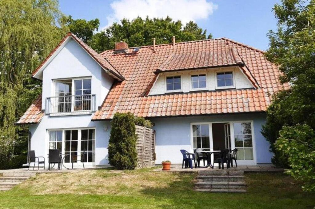 a white house with a table and chairs at Apartments Blue House, Putbus in Putbus