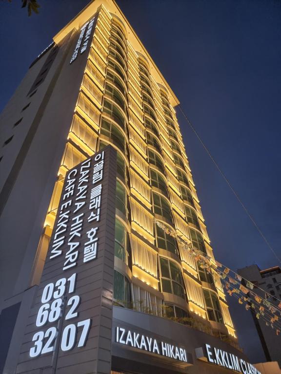 a tall building with a sign in front of it at EKklim Classic Hotel in Pyeongtaek