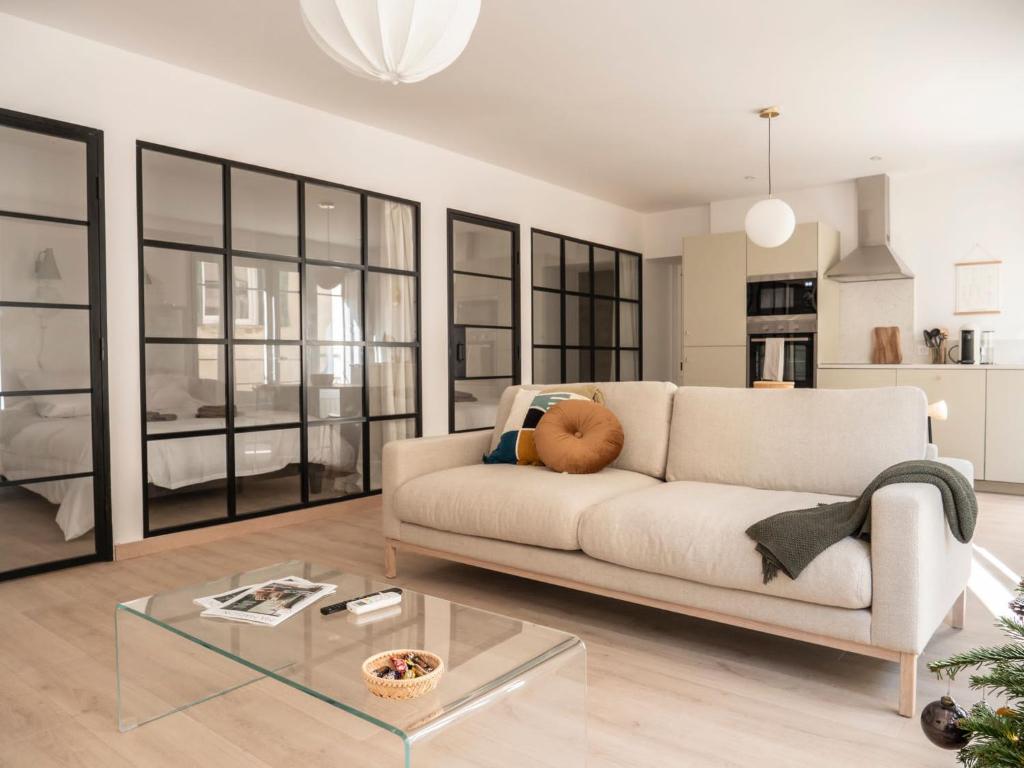 sala de estar con sofá blanco y mesa de cristal en L'ORANGERAIE Appartement design en plein centre en Castres