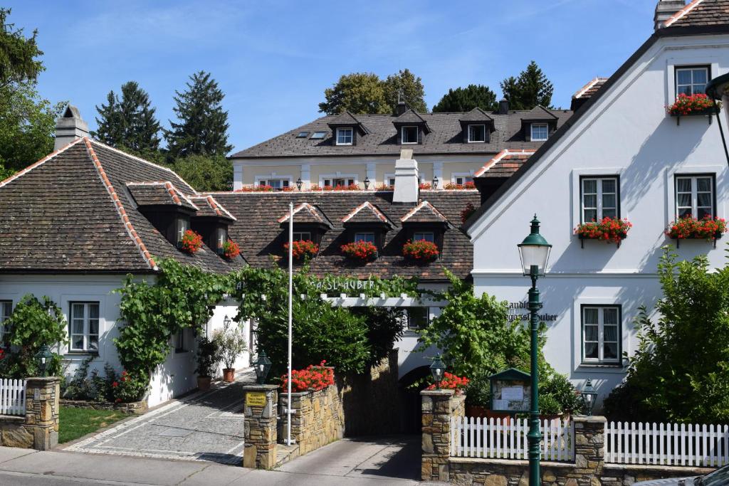 a white house with flowers on the windows at Hotel Landhaus Fuhrgassl-Huber in Vienna