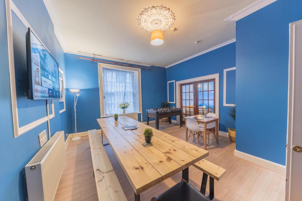 una sala da pranzo con tavolo in legno e pareti blu di Tivoli Guesthouse a Whitehaven