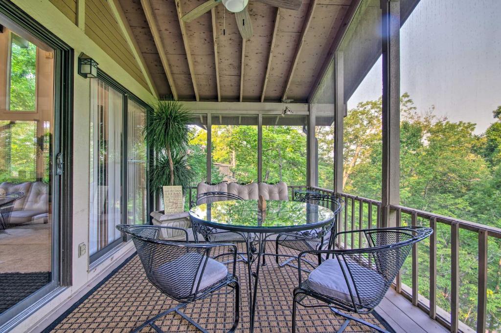 a screened in porch with a table and chairs at Osage Beach Getaway - 1 Mi to Margaritaville Fun! in Osage Beach