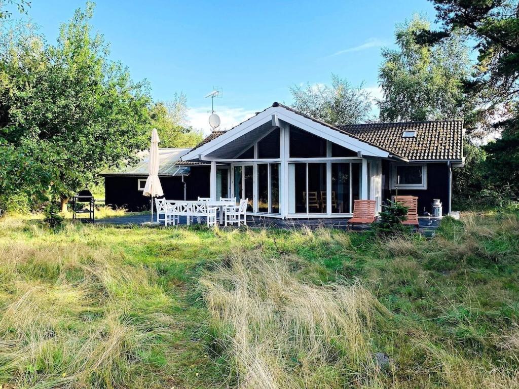 a small black house with a porch and a lawn at 8 person holiday home in Gedser in Gedser