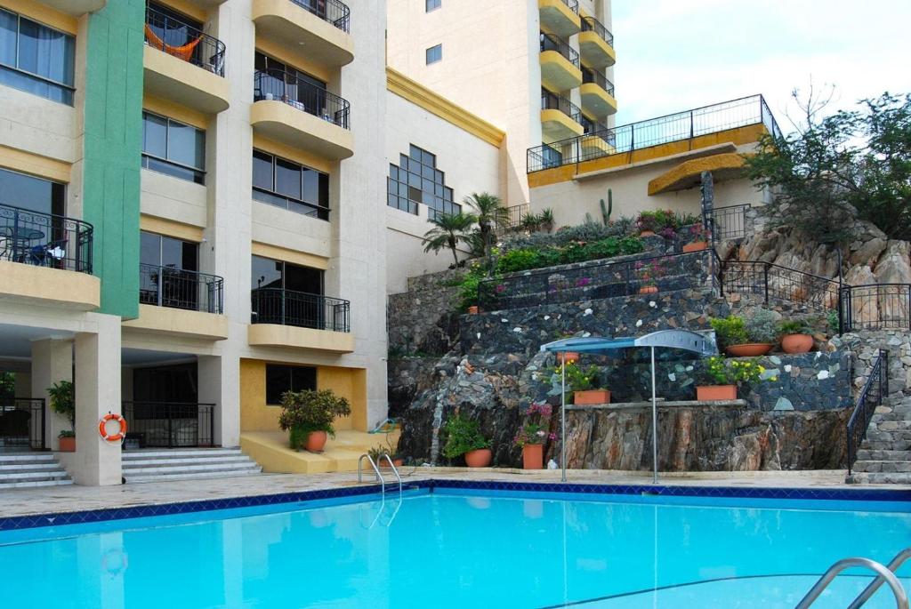 uma piscina em frente a um edifício em El peñón del rodadero em Santa Marta