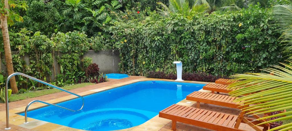 una piscina con 2 sillas y una piscina en Recanto Ubuntu, en Japaratinga