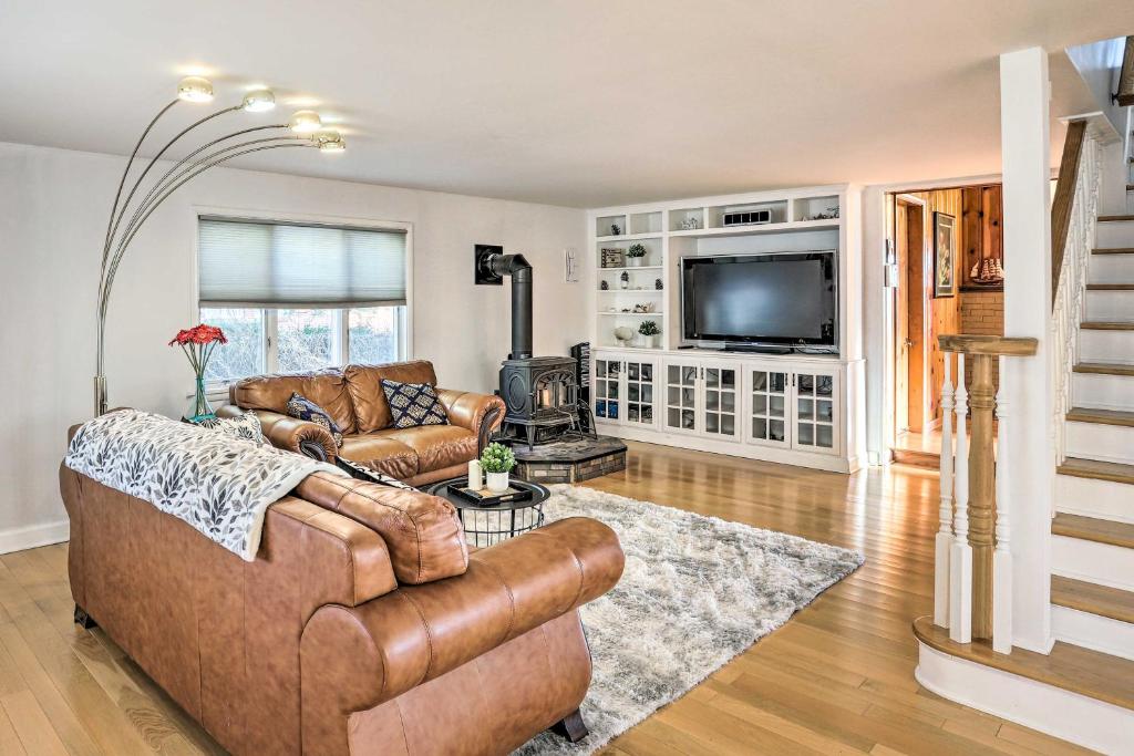 uma sala de estar com um sofá e uma televisão em Spacious Lakefront House with Backyard Fire Pit em Monroe