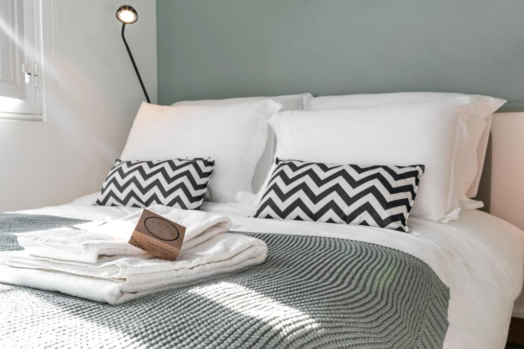 a bed with a towel and a book on it at Flat 23 in Bombarral