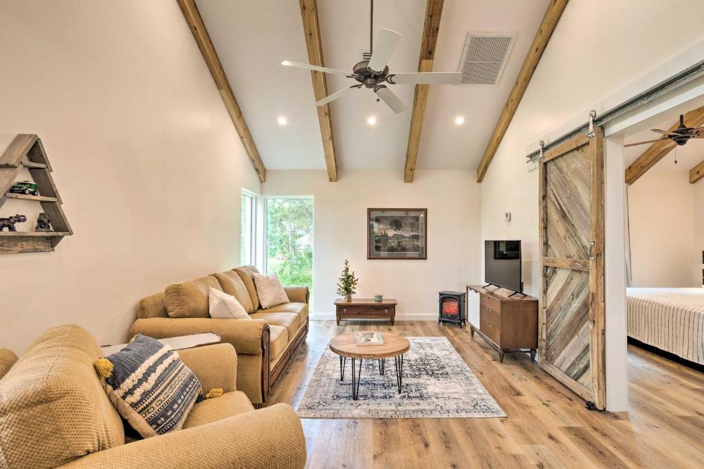 ein Wohnzimmer mit einem Sofa und einem Tisch in der Unterkunft Trendy Palm City Cottage with Porch on 5 Acres! in Stuart