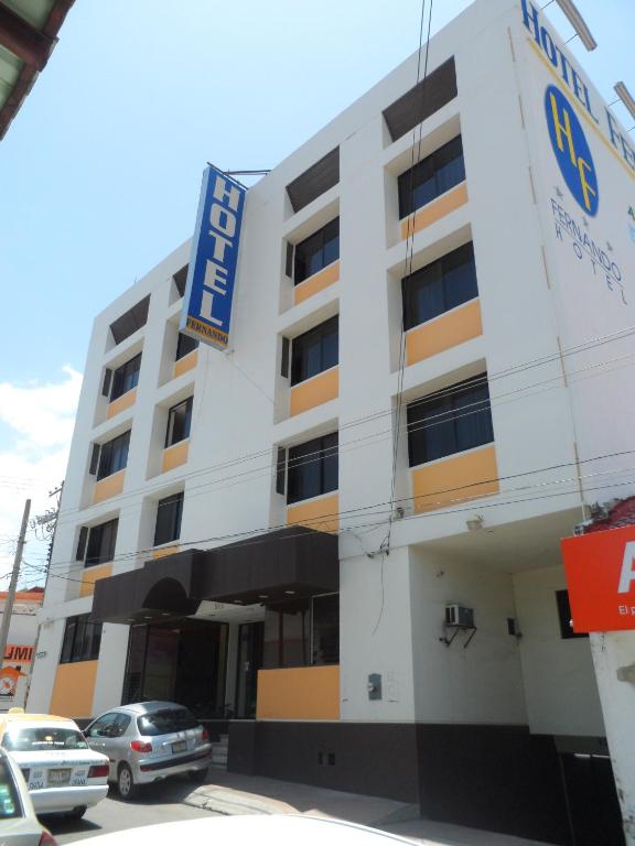 a building with cars parked in front of it at Hotel Fernando in Tuxtla Gutiérrez