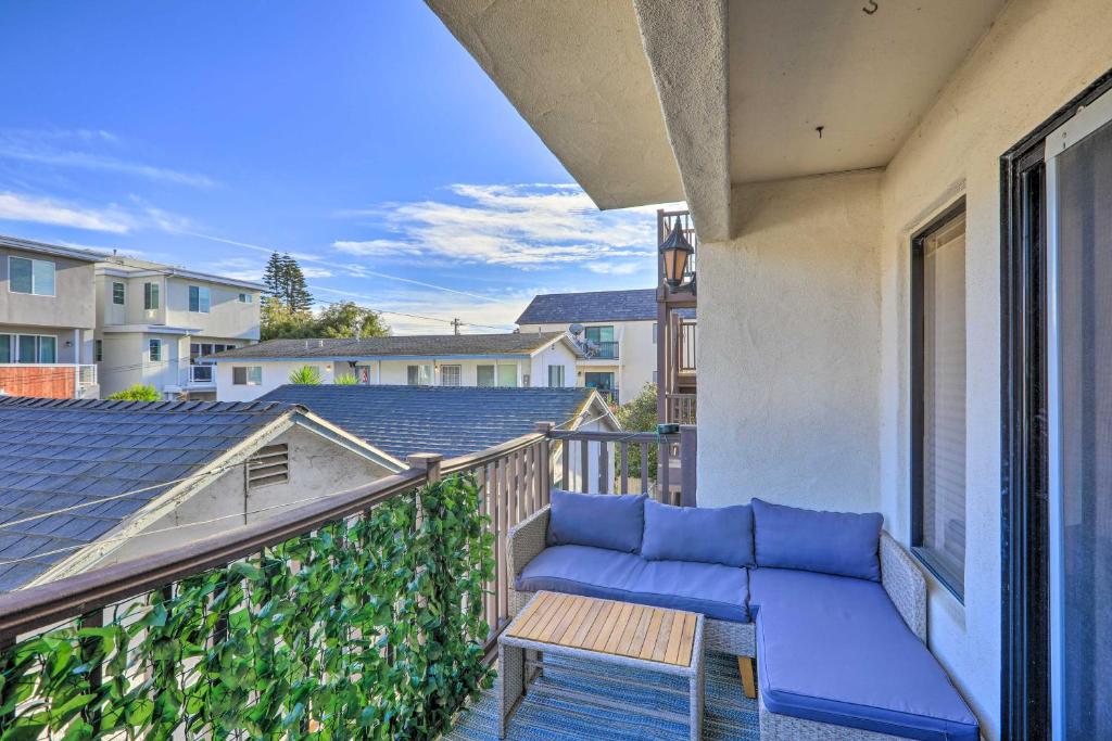 a balcony with a blue couch and a table at Pismo Beach Condo Less Than Walk to Beach and Wineries! in Pismo Beach