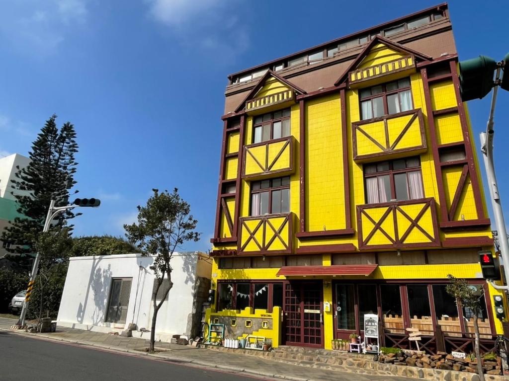 un edificio amarillo al lado de una calle en Sea House, en Magong