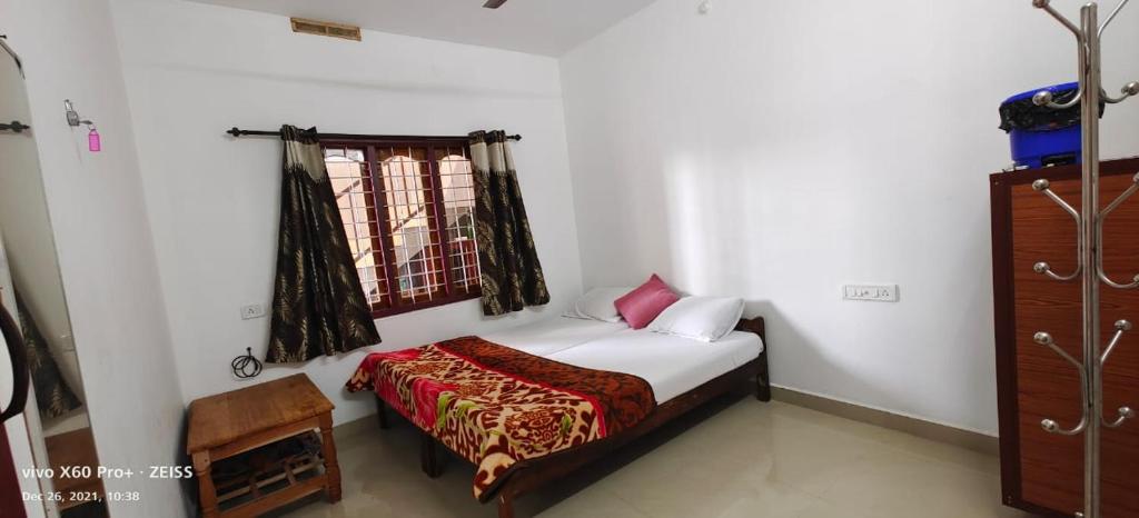 une petite chambre avec un lit et une fenêtre dans l'établissement Spice Cottage Homestay, à Thekkady