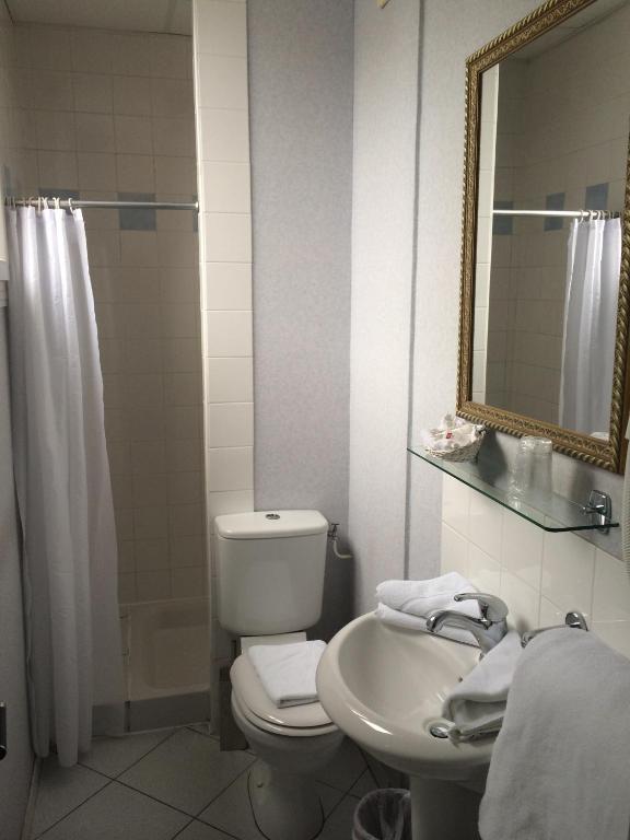 a bathroom with a toilet and a sink and a mirror at Hôtel Saint Alban in Saint-Maur-des-Fossés