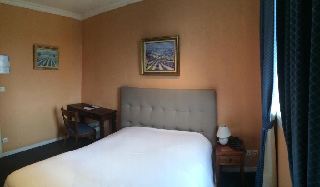 a hotel room with a bed and a desk and a bed sidx sidx at Hôtel Saint Alban in Saint-Maur-des-Fossés