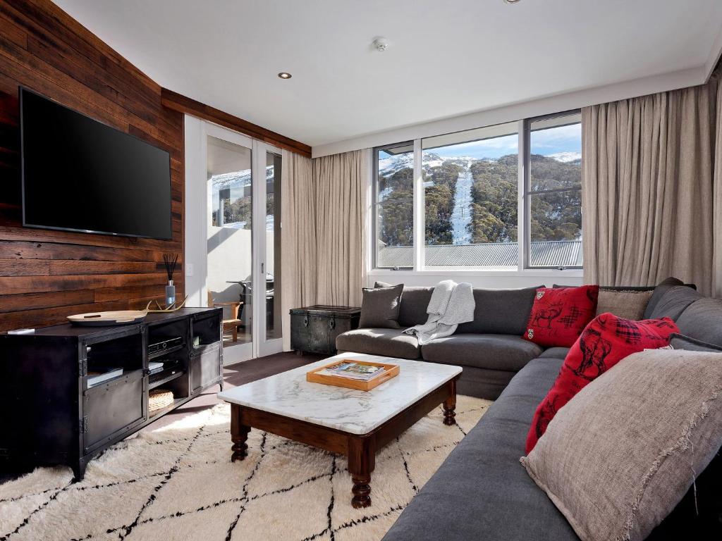 a living room with a couch and a tv at KoKo Nanook Squatters 15 in Thredbo
