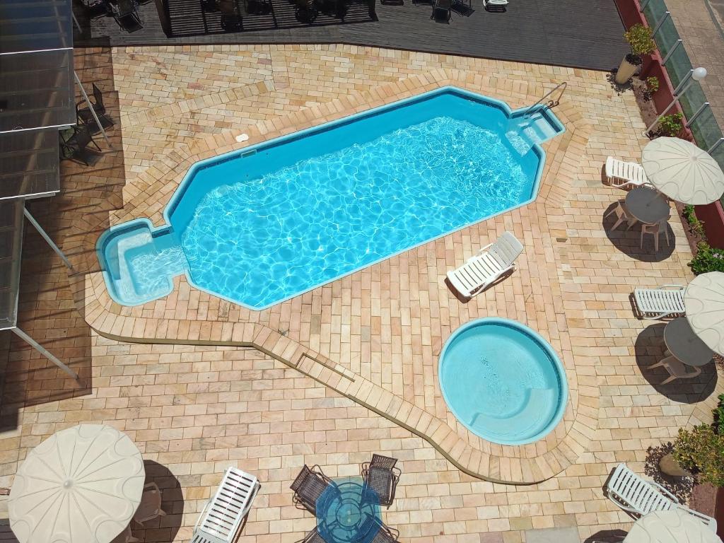 una vista aérea de una piscina con sillas y sombrillas en De Rose Praia Hotel en Torres