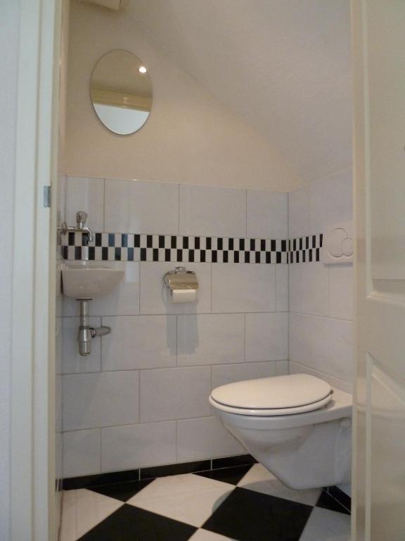 ein Badezimmer mit Toilette und Waschbecken in der Unterkunft Appartement "Zicht op de Vuurtoren" in Noordwijk aan Zee