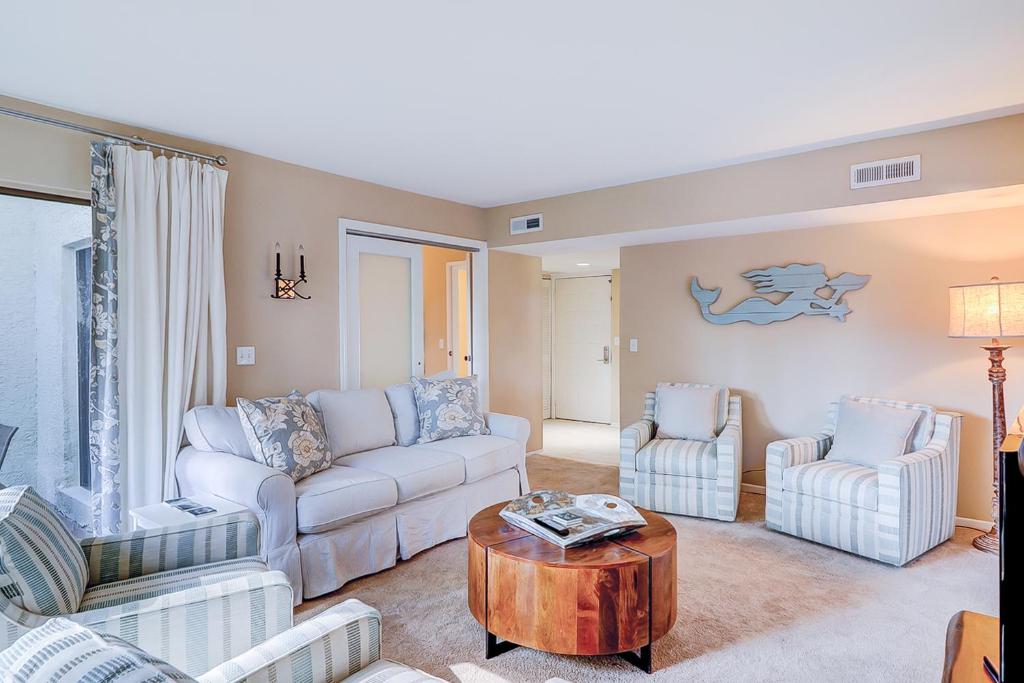 a living room with two couches and a table at Harbour Master 103 in Hilton Head Island