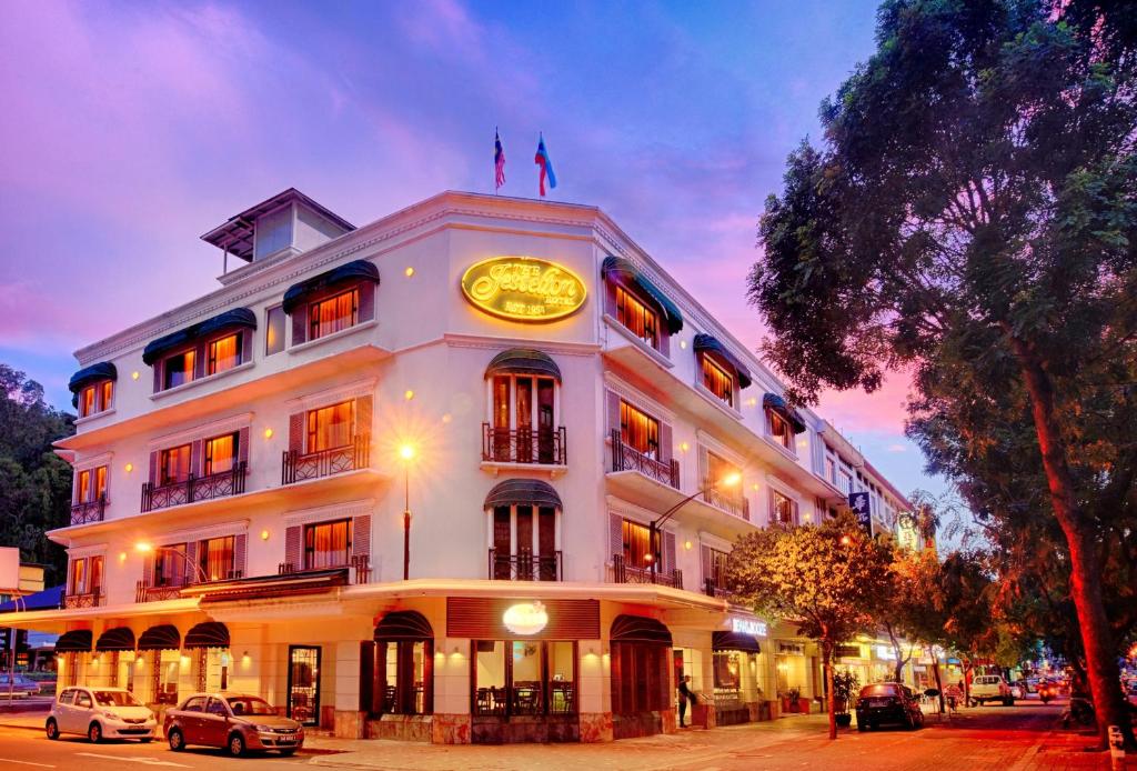 a large white building with a clock on it at The Jesselton Hotel in Kota Kinabalu