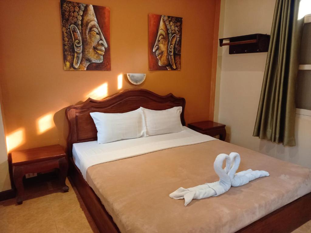 Un dormitorio con una cama con un animal de toallas. en Manichan Guesthouse, en Luang Prabang