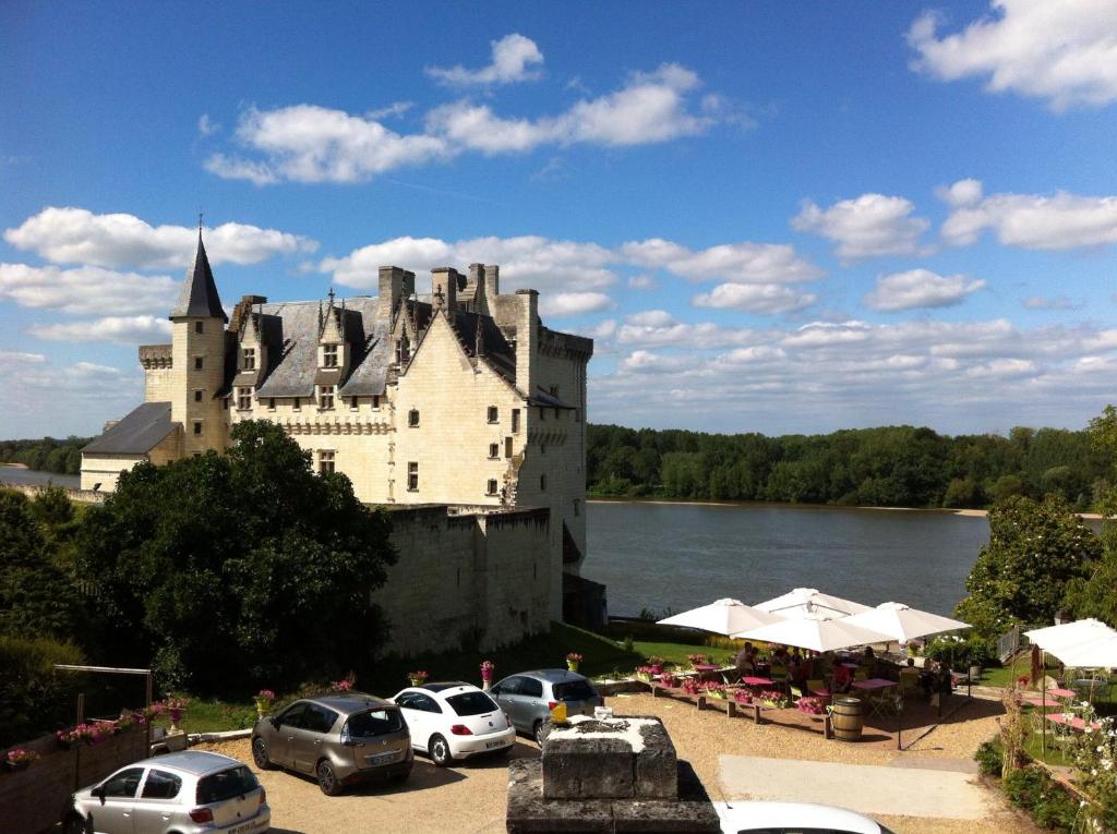 a castle with cars parked in front of it at Hotel Le Bussy in Montsoreau