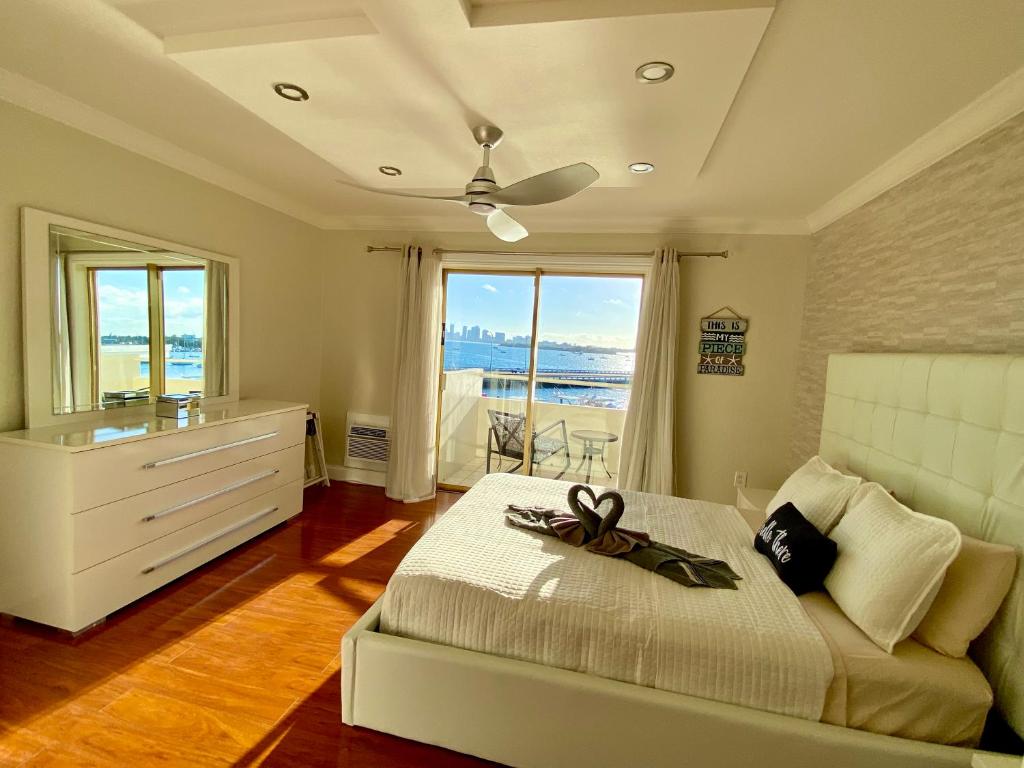 ein Schlafzimmer mit einem Bett mit einer Kommode und einem Fenster in der Unterkunft Deluxe waterfront one bedroom apartment with Miami Skyline view, free parking 5 mins drive to Miami Beach in Miami Beach