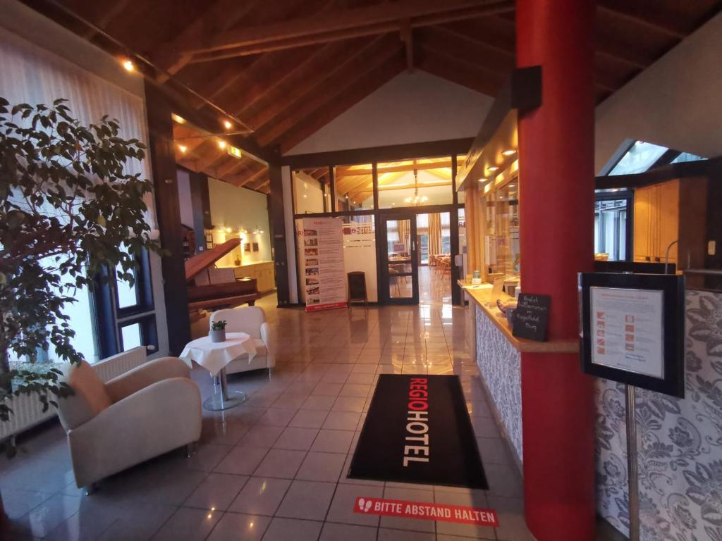 a lobby with couches and a welcome mat on the floor at REGIOHOTEL Wittekind Burg in Burg bei Magdeburg