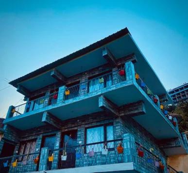 ein blaues Gebäude mit Balkon davor in der Unterkunft Mountains Facing Homestay in Jyotirmath