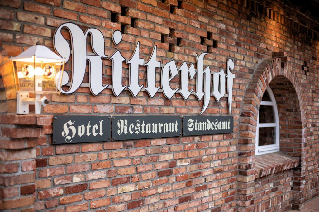 a brick wall with a sign on a building at Ritterhof Kampehl in Neustadt