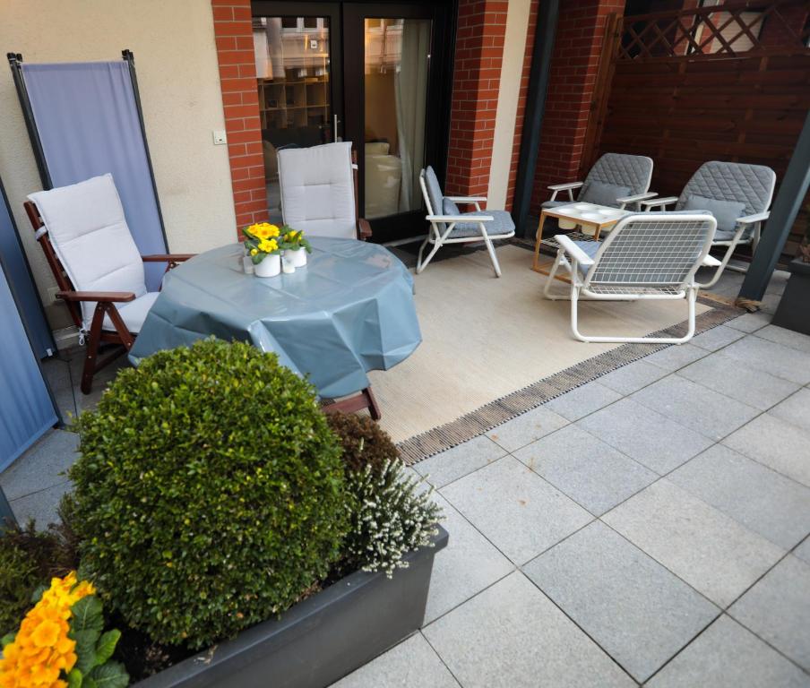 une table bleue et des chaises sur une terrasse dans l'établissement ruhige Terrassen-Whg. 68qm im Stadtzentrum (bis 5 Personen) checkin123, à Wiesbaden