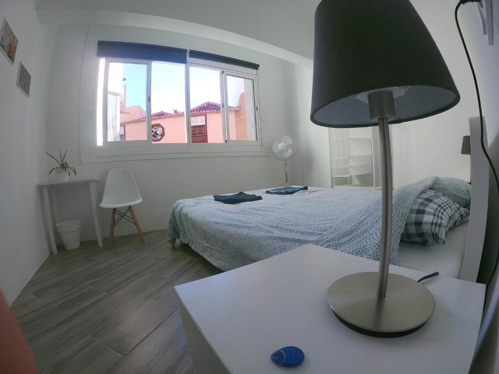 1 dormitorio con 1 cama y 1 lámpara en una mesa en Room with Private Bathroom - Vivienda Vacacional Out of Blue, en Santa Cruz de la Palma