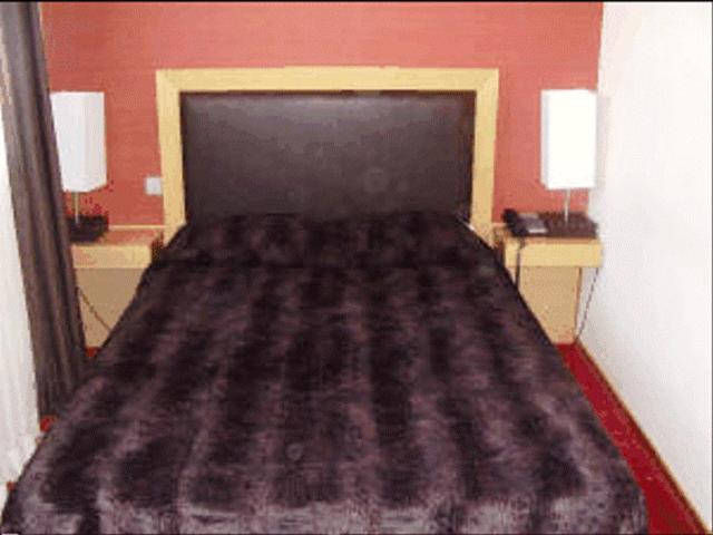 a bedroom with a large bed with two night stands at Aegli Hotel in Grevena