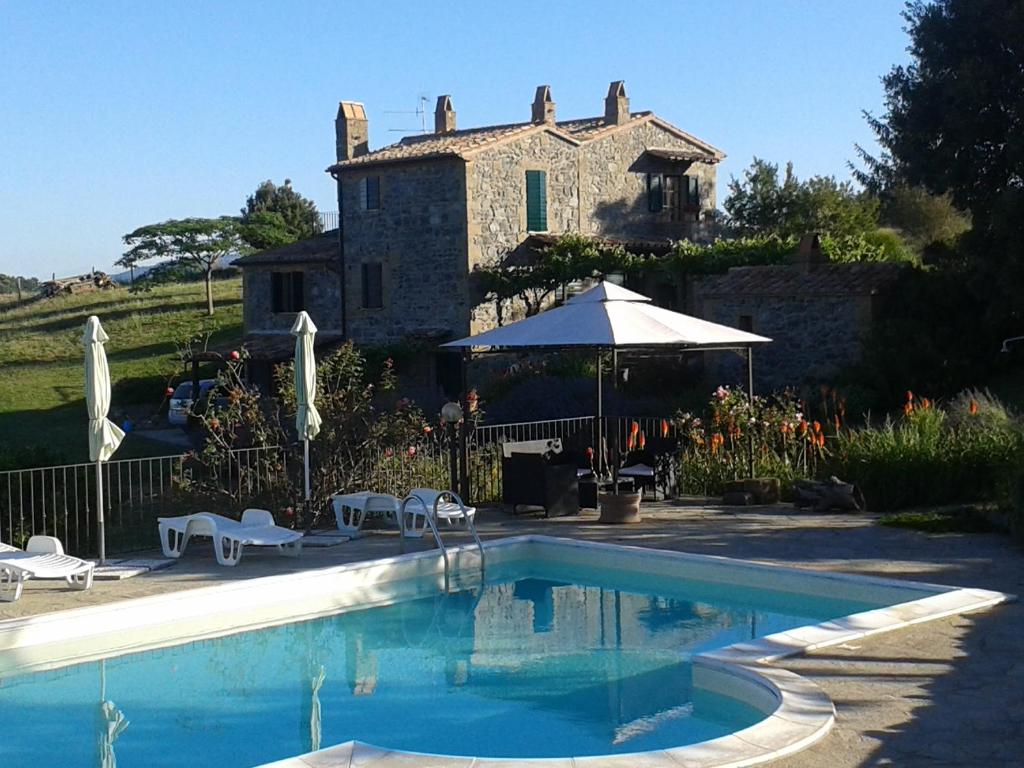 a house with a swimming pool in front of a building at Agriturismo Cantinaccia di Sopra in Pitigliano