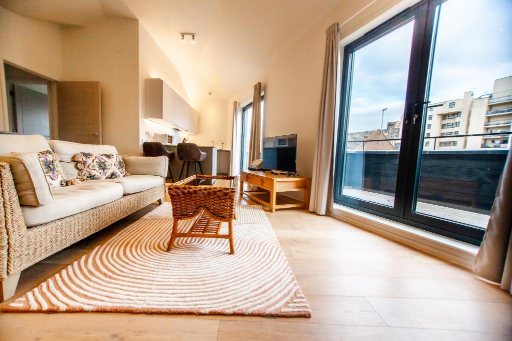 a living room with a couch and a large window at The Hideaway 2mins To The Beach in Hastings