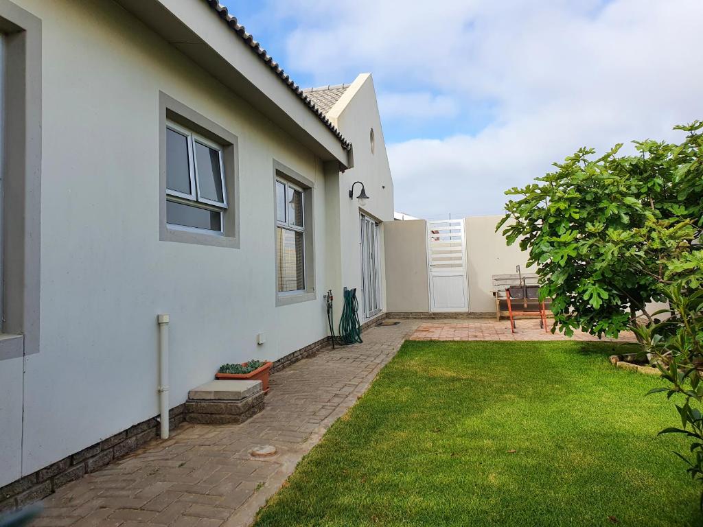 a white house with a lawn in front of it at Acacia Four Seven Self-Catering in Swakopmund