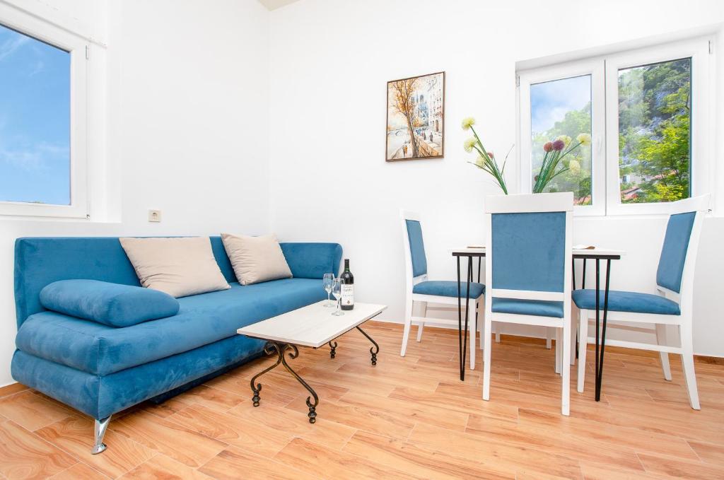een woonkamer met een blauwe bank en 2 stoelen bij Apartments Golden View in Kotor