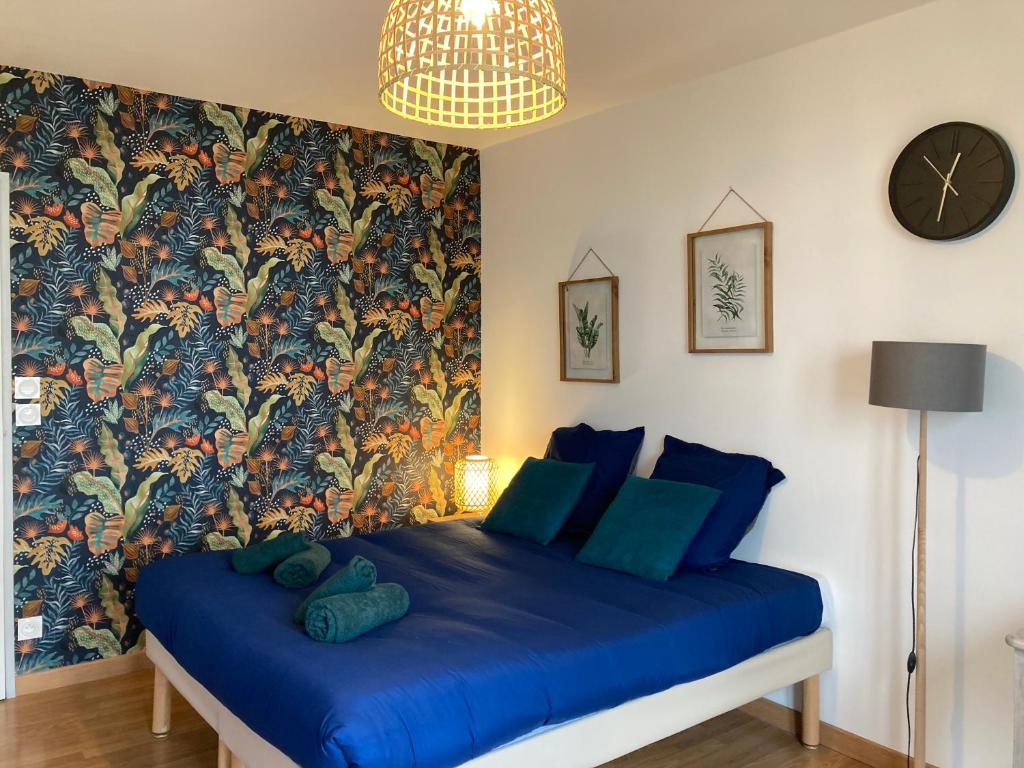um quarto com uma cama azul e papel de parede floral em Lumineux Studio 30m² sur Cour - Proche Tram/Centre em Nantes