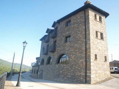 a large stone building with a street light next to it at Apartamentos Pirineos Ordesa in El Pueyo de Araguás