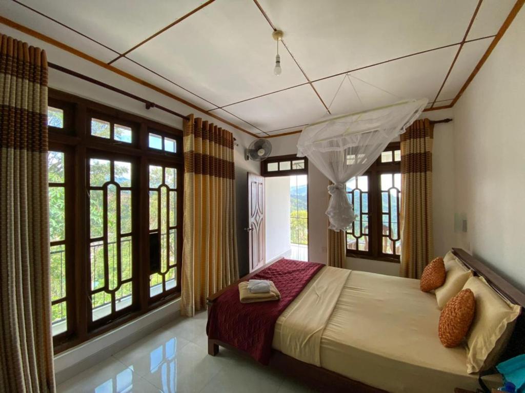 a bedroom with a bed in a room with windows at Maple Home Stay in Ella