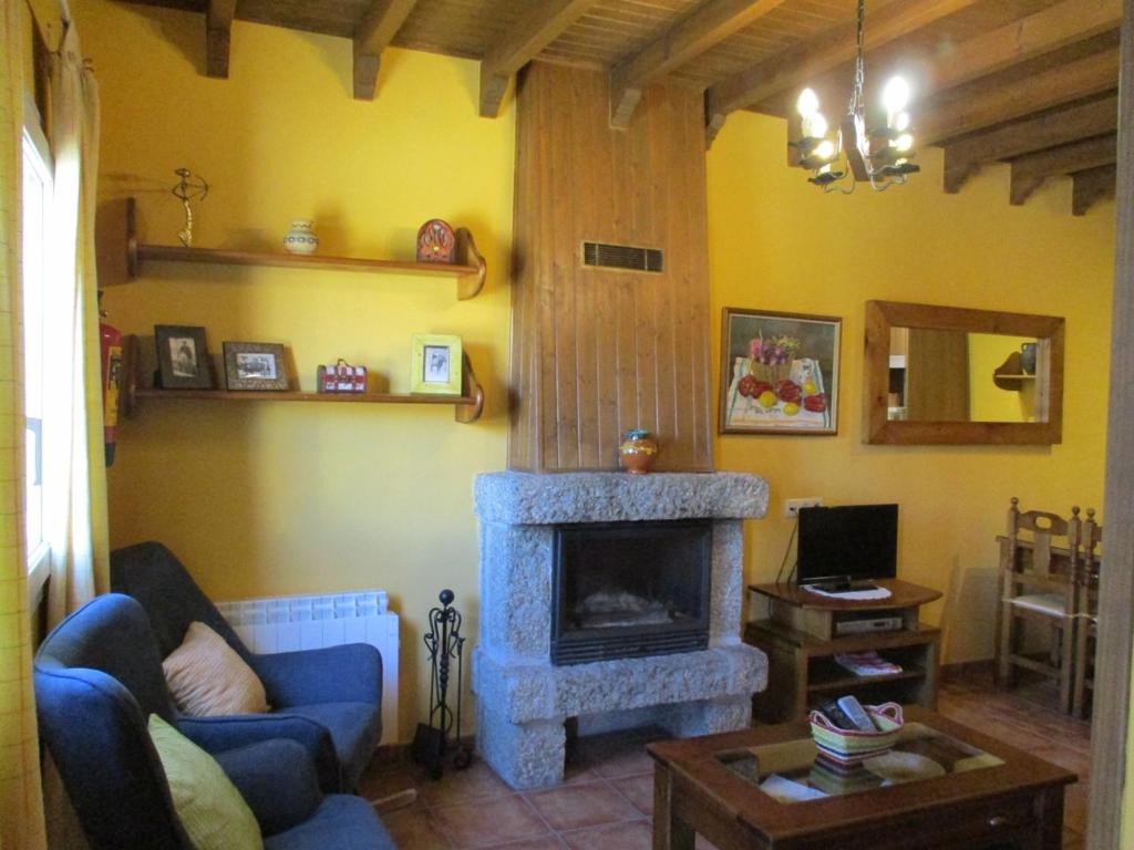 uma sala de estar com um sofá azul e uma lareira em Casa Rural Fuente Tía Canora em Solosancho