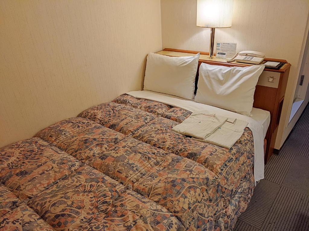 Postel nebo postele na pokoji v ubytování Ace Inn Kariya