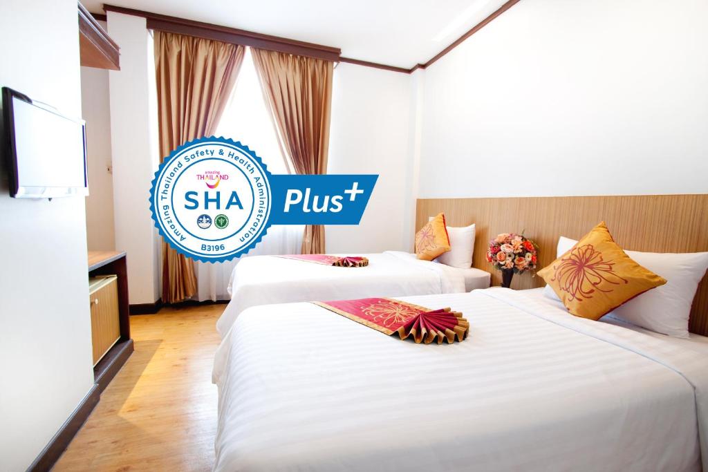 dwa łóżka w pokoju hotelowym z znakiem w obiekcie China Town Hotel - SHA Plus Certified w mieście Bangkok